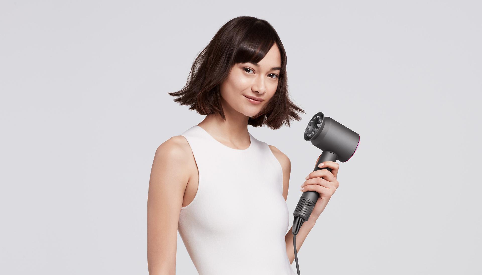 Dyson Supersonic hair dryer used by woman to style her bob hairstyle