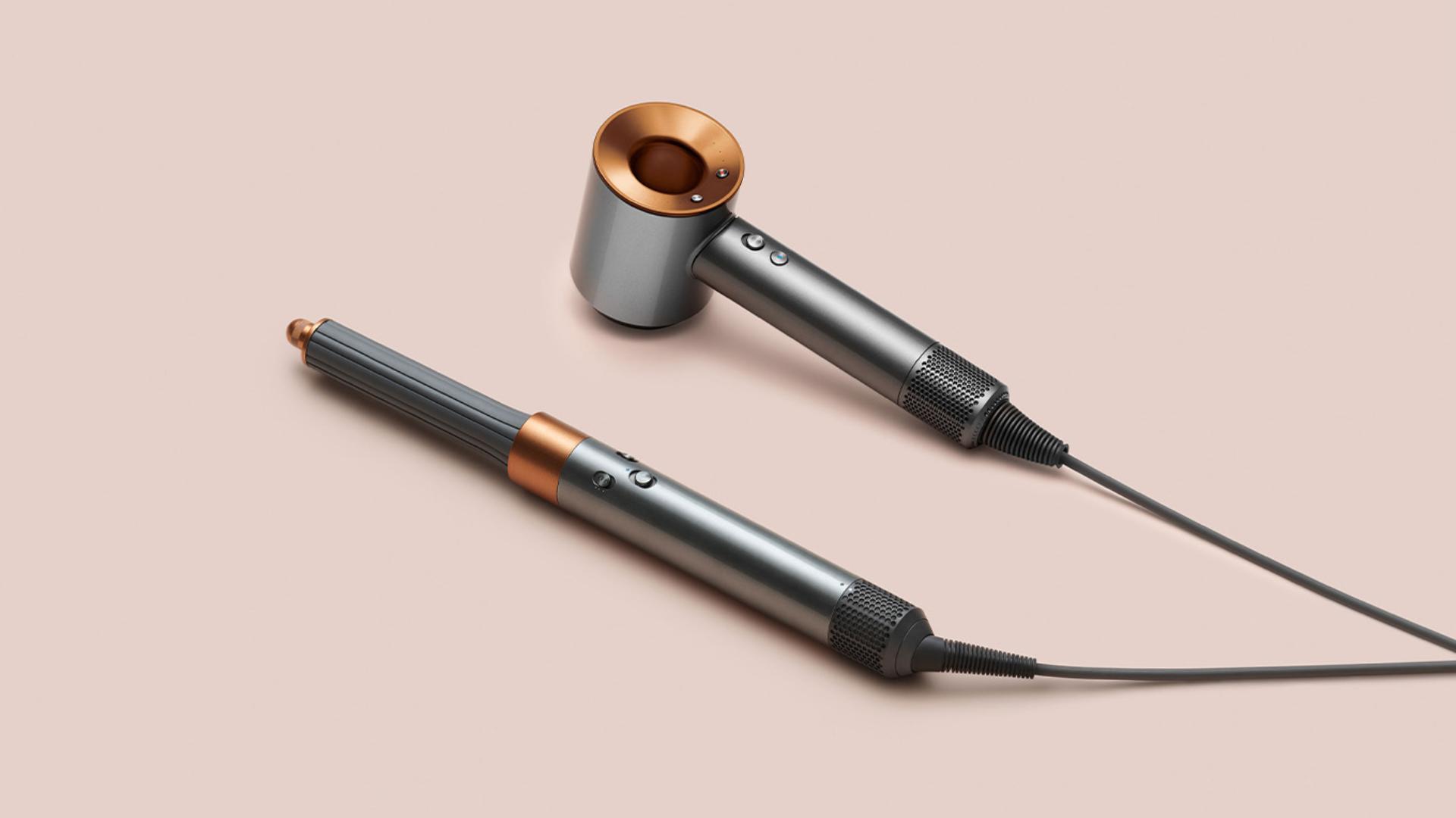 Multistyler Dyson Airwrap i suszarka do włosów Dyson Supersonic na różowym tle