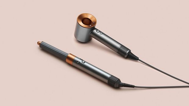 Multistyler Dyson Airwrap i suszarka do włosów Dyson Supersonic na różowym tle