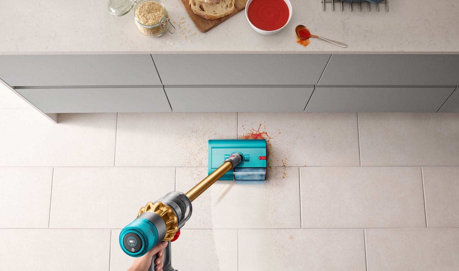 The Dyson V15s Detect Submarine wet and dry vacuum cleaner being used to clean spilled soup in the kitchen.