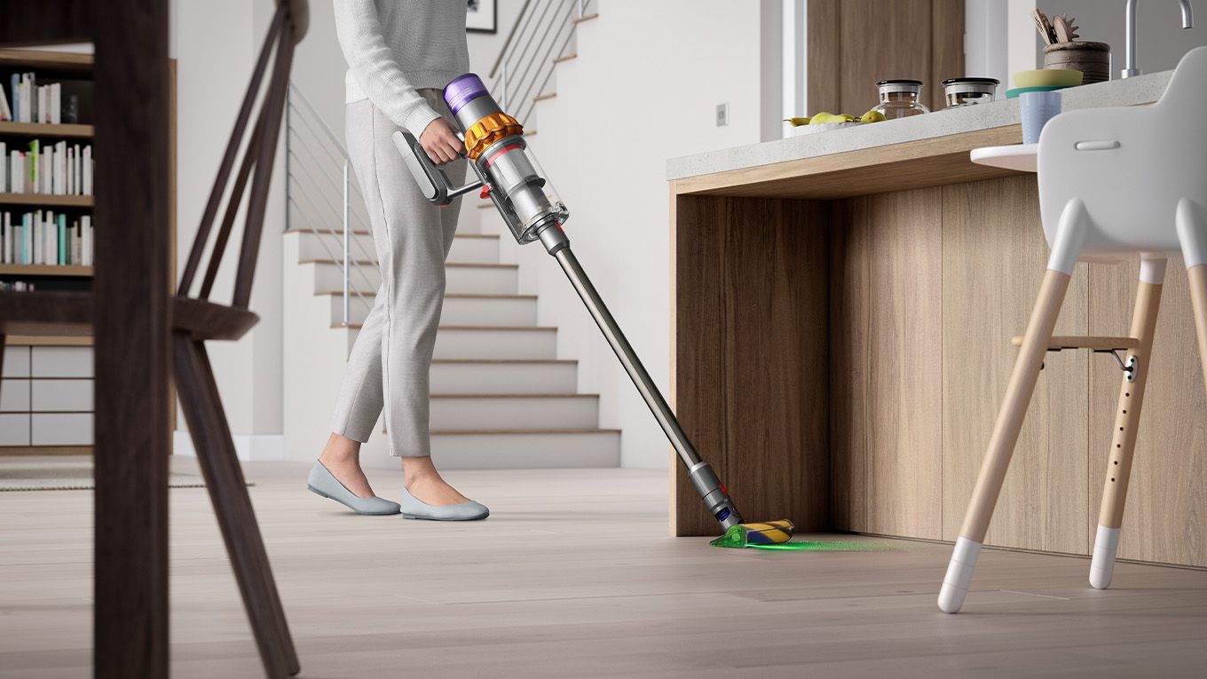 The Dyson Fluffy Optic cleaner head being used to illuminate and vacuum dust in the living room.
