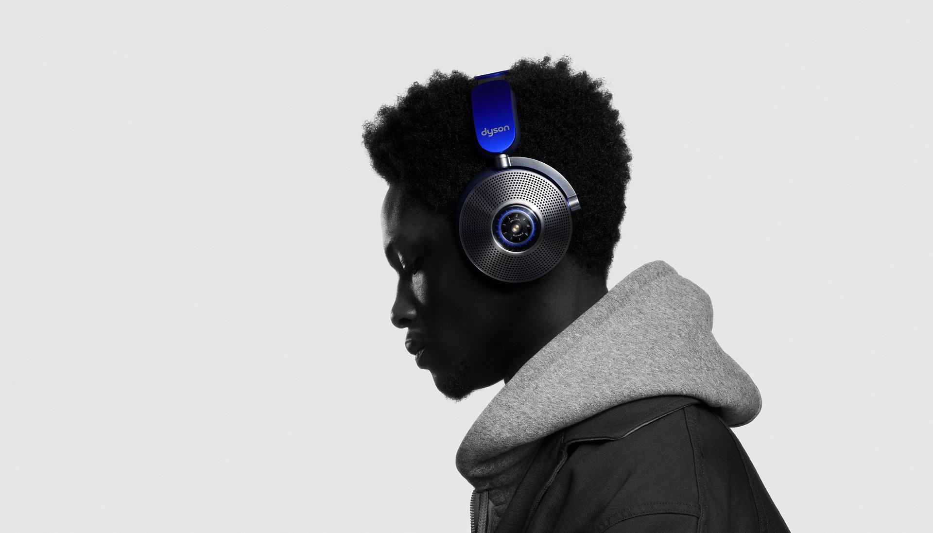 The side profile of a model standing against a white background while wearing his Dyson Zone noise cancelling headphones.
