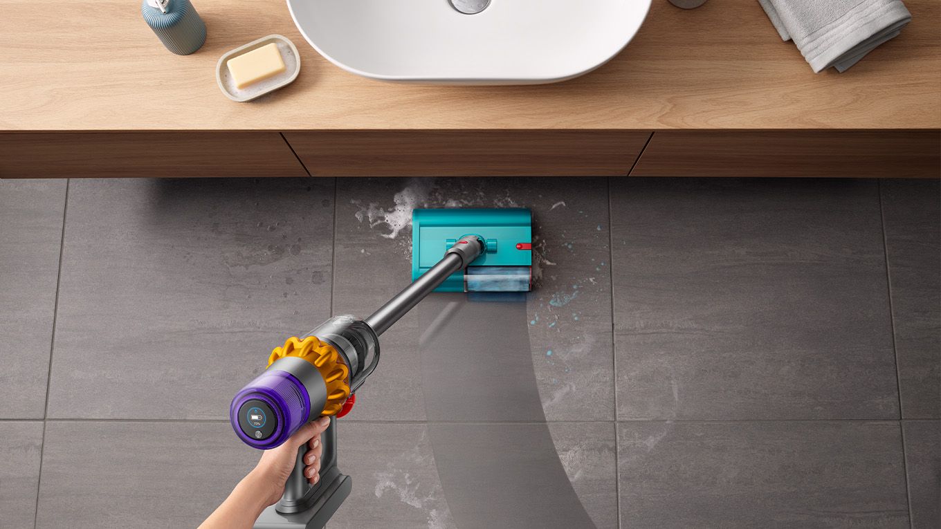 Dyson Submarine wet roller head used to clean bathroom floor by sink Dyson Submarine wet roller head used to clean bathroom floor by sink