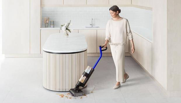 Kobieta sprzątająca podłogę w kuchni wysokoobrotowym mopem elektrycznym Dyson WashG1