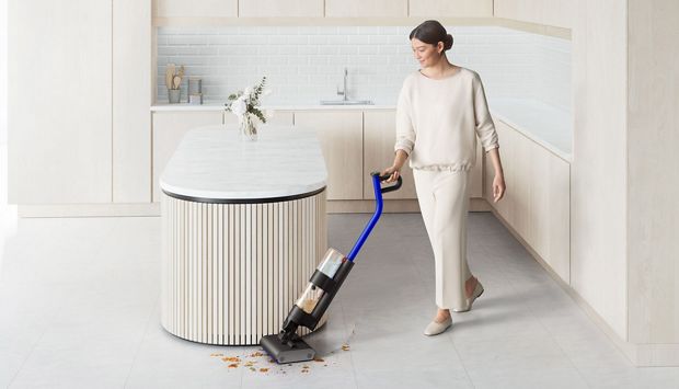 Kobieta sprzątająca podłogę w kuchni wysokoobrotowym mopem elektrycznym Dyson WashG1
