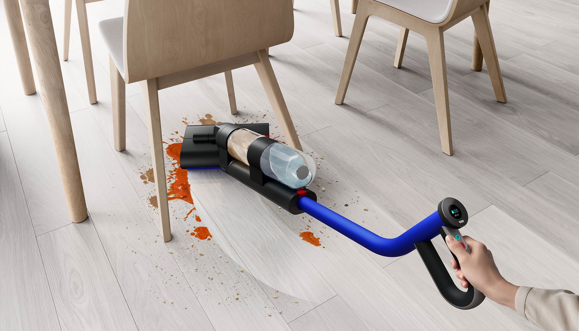 Wysokoobrotowy mop elektryczny Dyson WashG1™ w trakcie usuwania rozlanego pod krzesłem kuchennym płynu