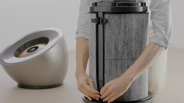 Gros plan d'un filtre à charbon actif en train d'etre changé