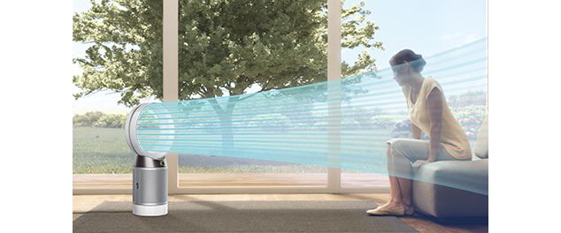 Femme assise devant un flux d'air émis par le ventilateur purificateur Dyson Pure Cool.