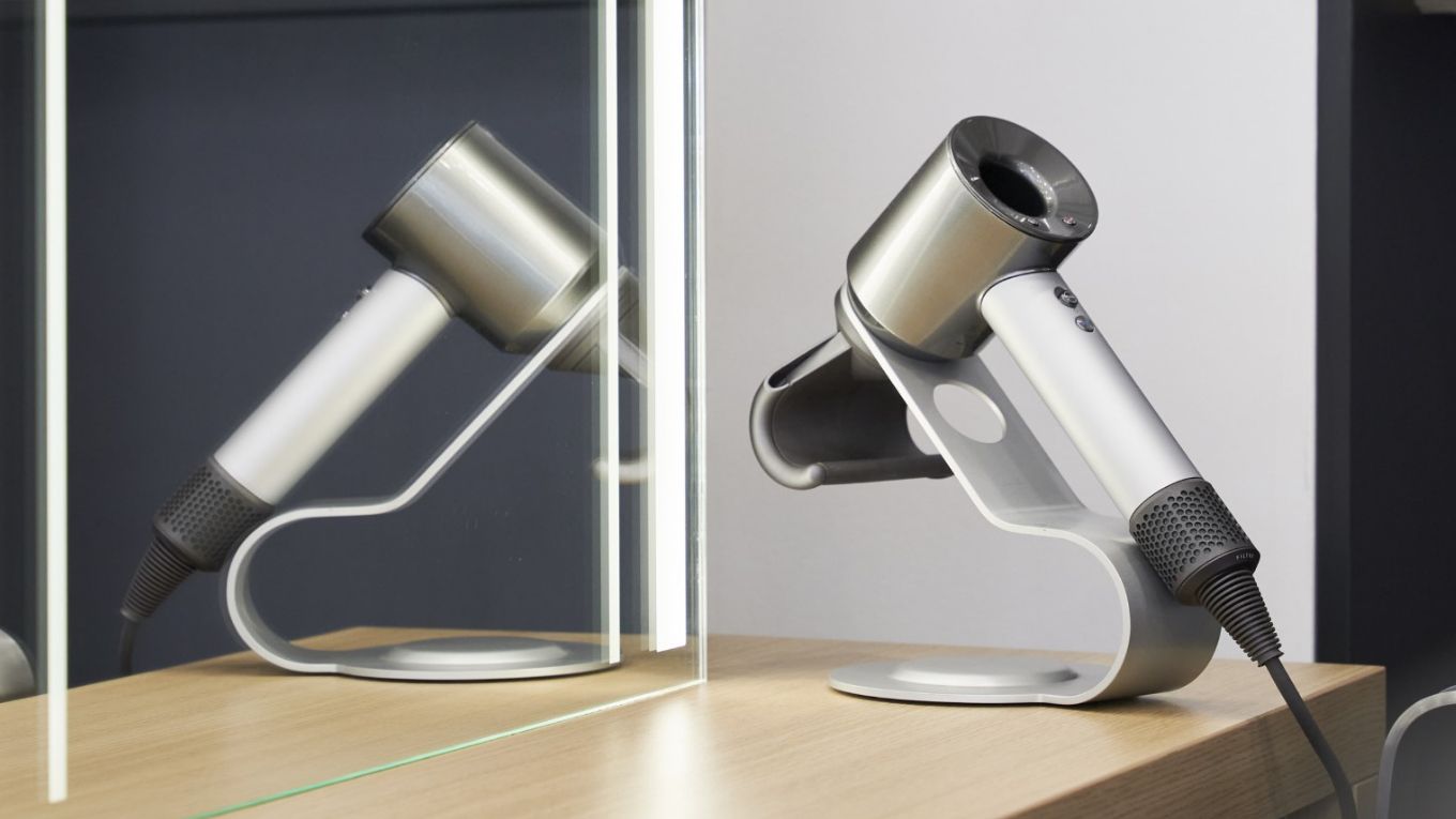 Dyson Supersonic hair dryer on a desk in a hotel room