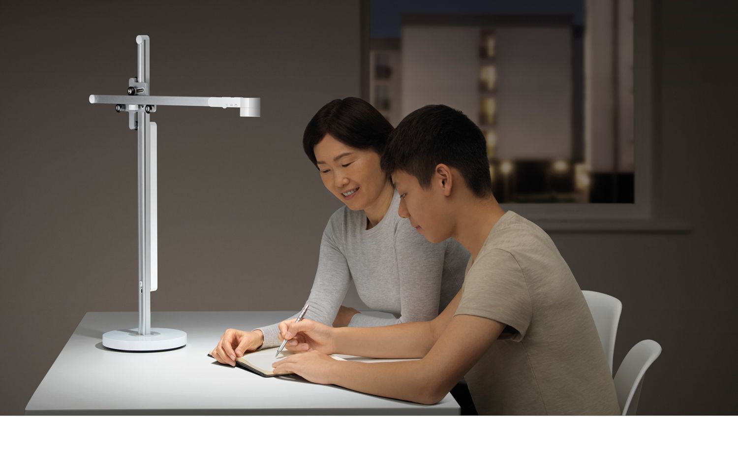 Une mère et son fils étudiant sous une lampe Dyson Lightcycle