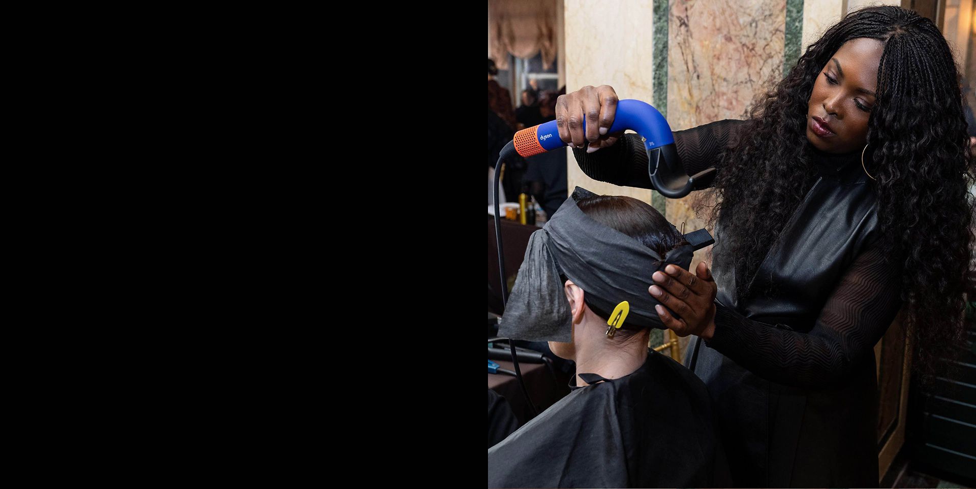 Model having hair styled by a stylist using a Dyson Supersonic r Professional hair dryer.