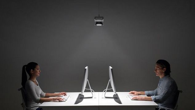 To personer som jobber på datamaskiner med belysning fra Cu-beam