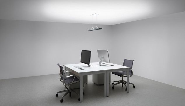 Dyson Cu-beam-lampe over et skrivebord og stoler.