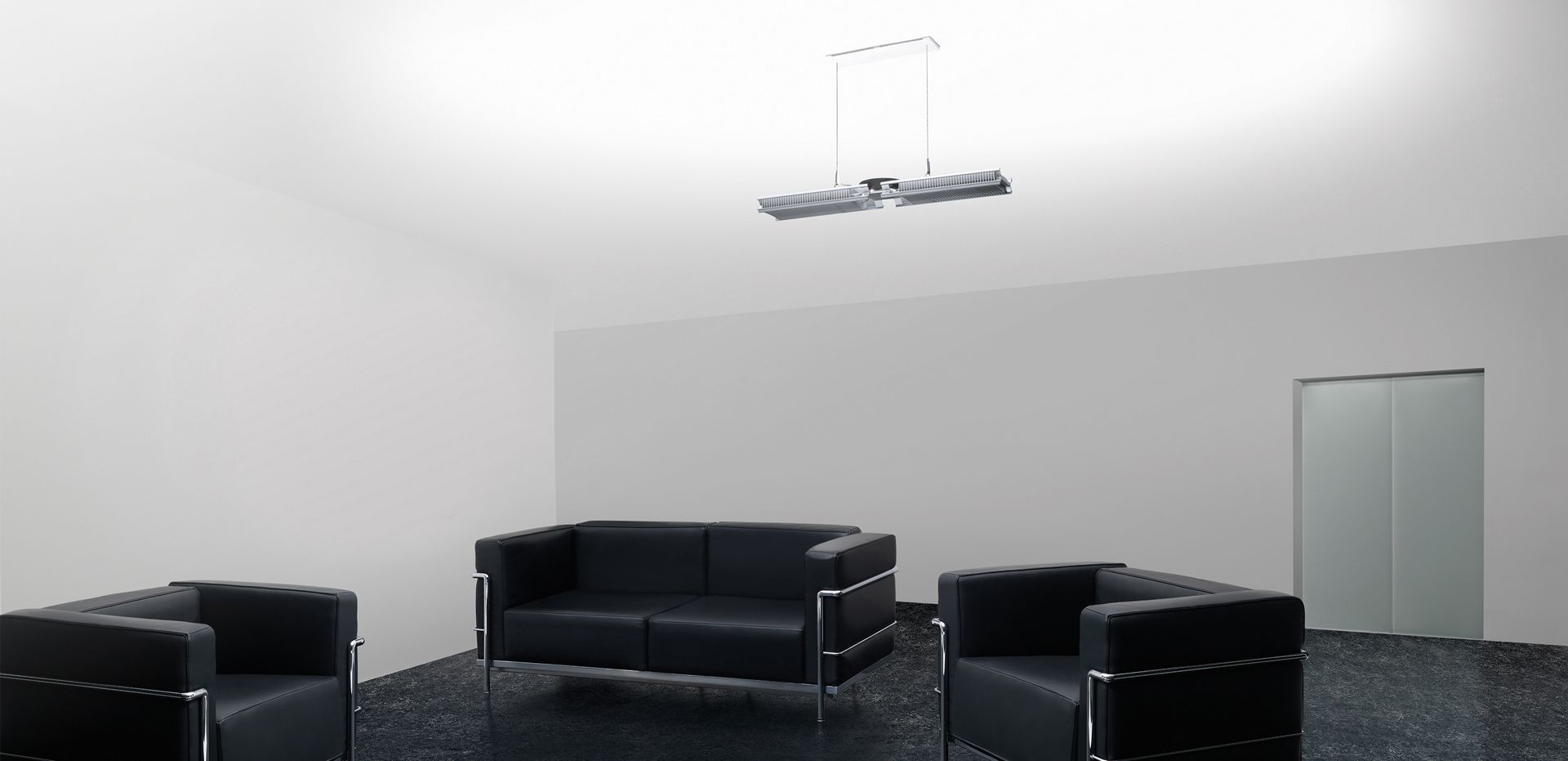 Dyson Cu-beam Up-lampe over sofaer i en kontorlobby. 