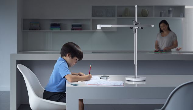 Child studying under Dyson Lightcycle desk light.