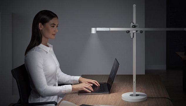 Dyson lightcycle desk shining light over woman working on laptop