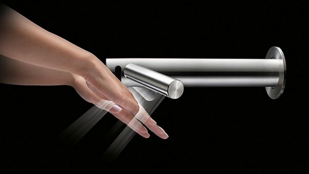 黒を背景に、ダイソンのハンドドライヤー「Dyson Wash+Dry」で手を乾かす人