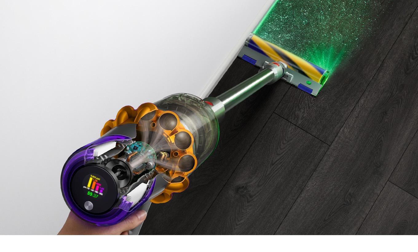 The Dyson V15 Detect Absolute vacuum sucking up dust from a hard floor