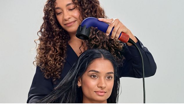 A stylist drying a model's hair with the Dyson Supersonic r hair dryer