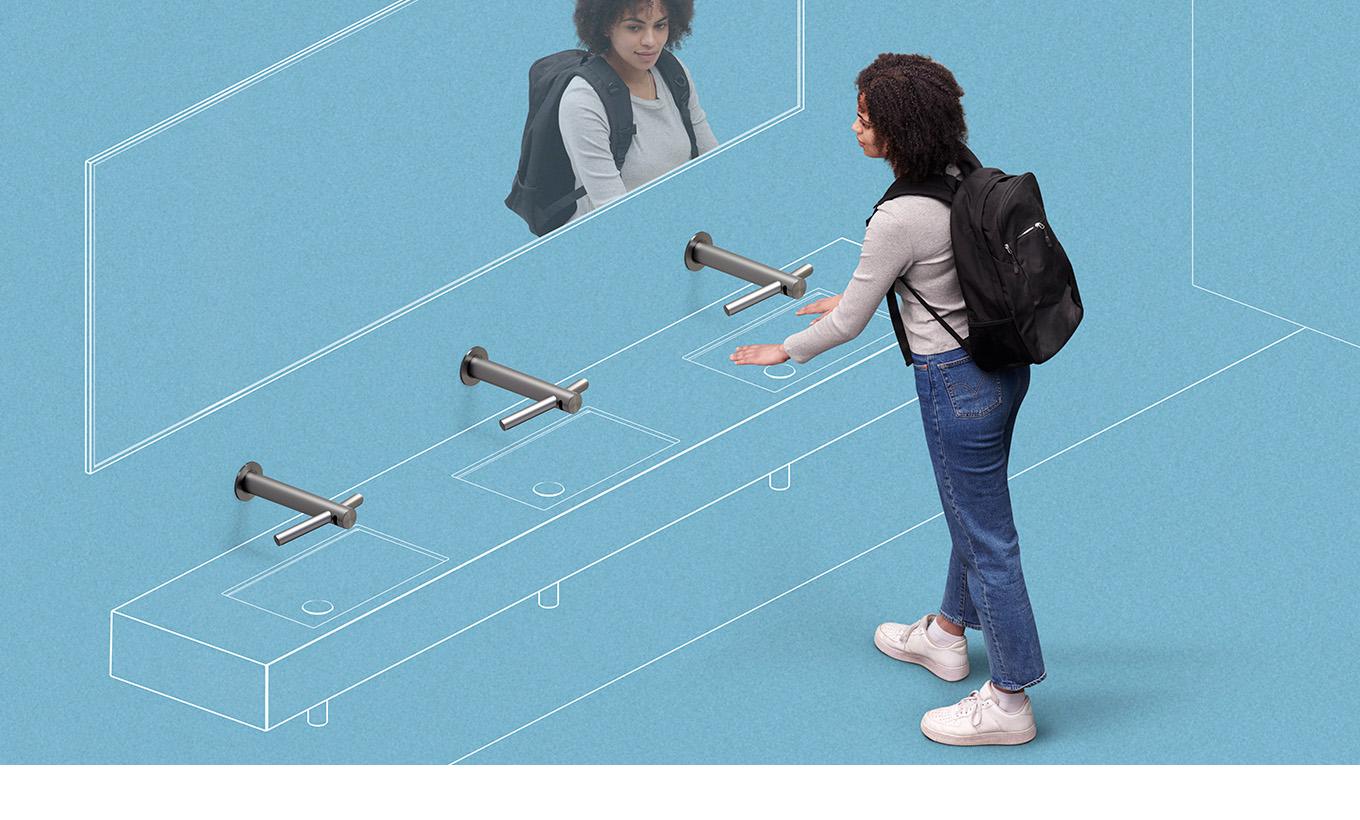 A woman drying her hands under the Dyson Airblade hand dryer