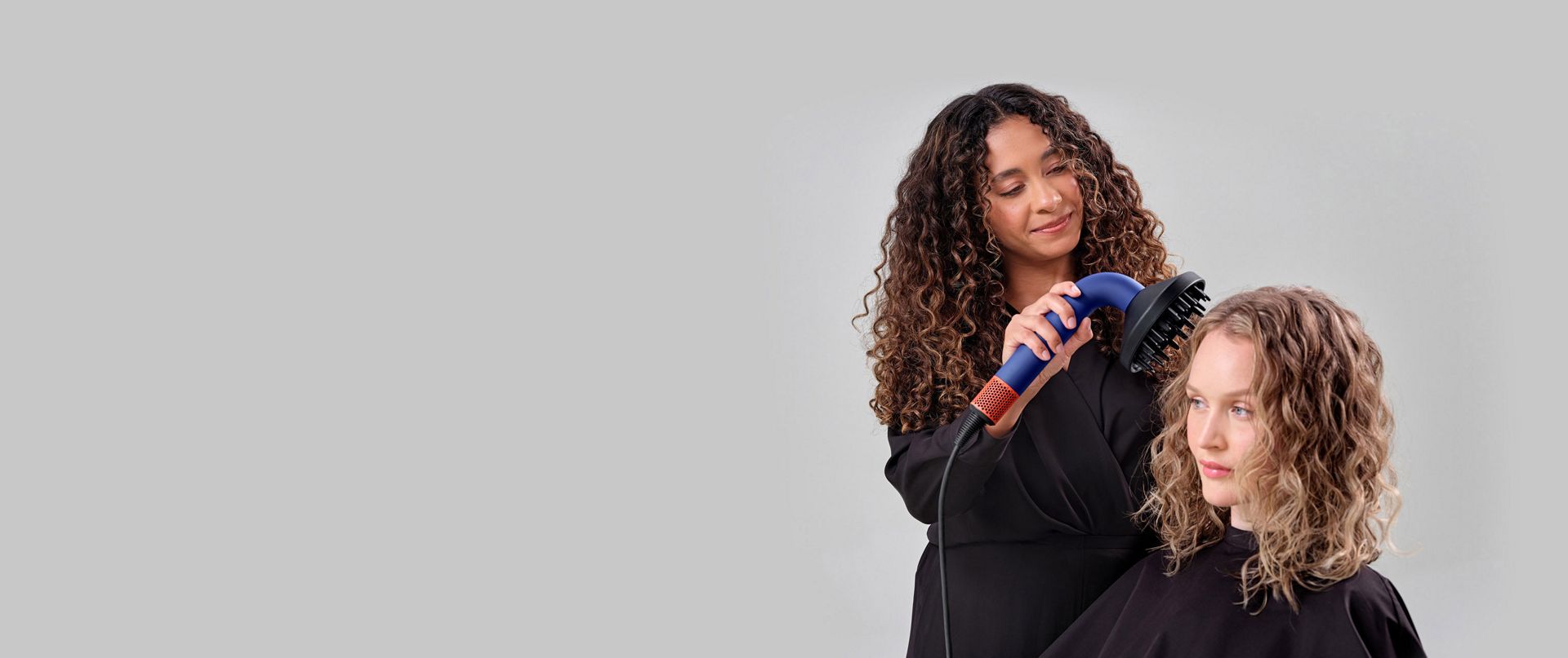 Dyson Supersonic r hair dryer with Powerful air attachment is used on a model to dry hair, before the Pro concentrator is then connected to the machine to smooth the model's hair to finish the style.