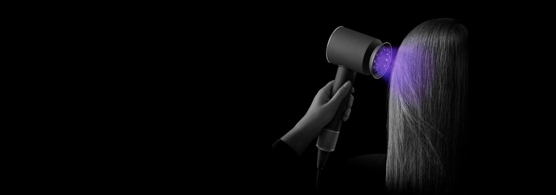 The Dyson Supersonic Professional hair dryer in Bright copper being used on straight hair.