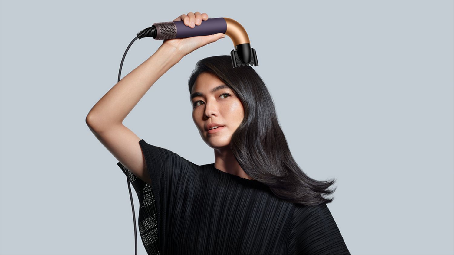 The Dyson Supersonic r Professional hair dryer in Bright copper being used by a model.