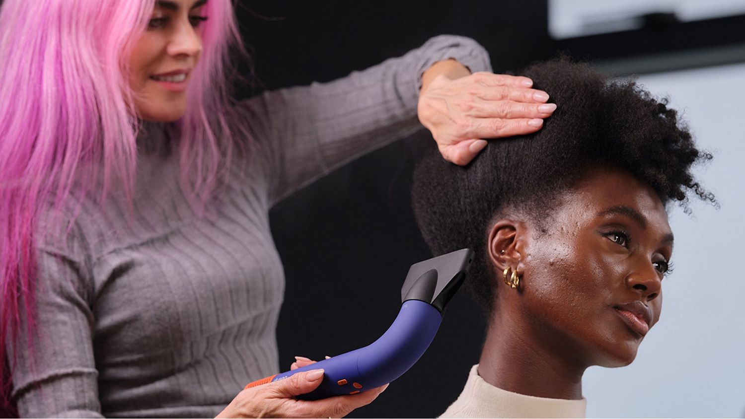 Global Styling Ambassador dries model's hair with Dyson Supersonic r Professional hair dryer with Intelligent attachment.