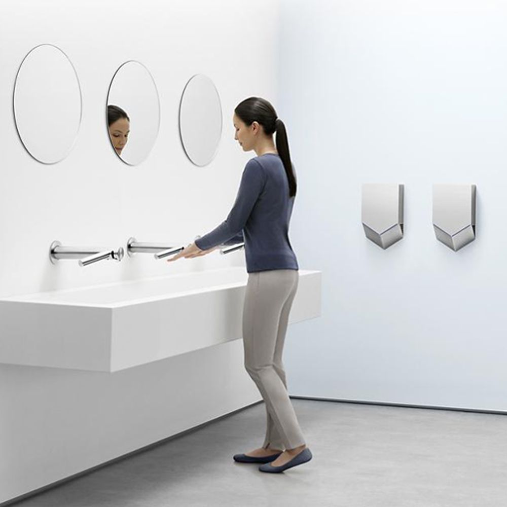 Frau in einem Waschraum, die Dyson Wash + Dry verwendet