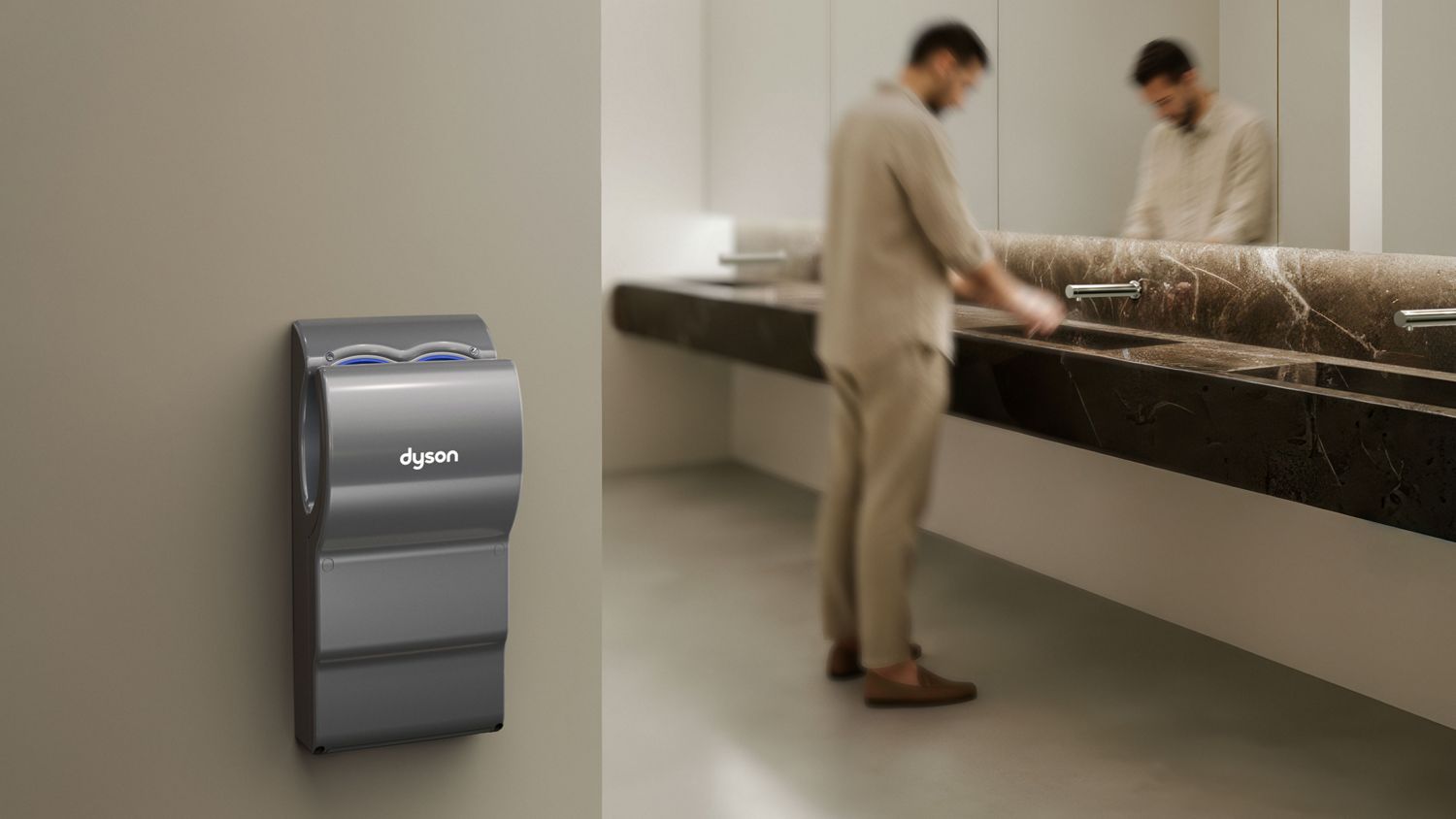 A Dyson Airblade dB hand dryer near a sink in a bathroom.