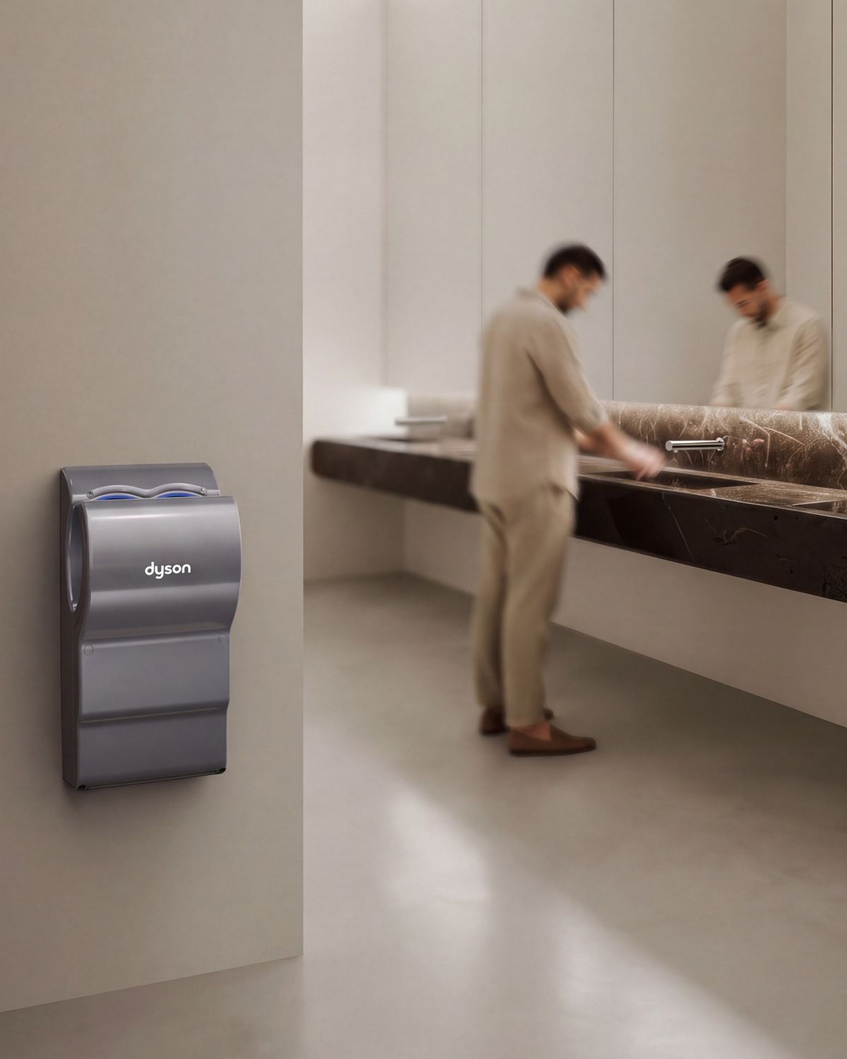 A Dyson Airblade dB hand dryer near a sink in a bathroom.