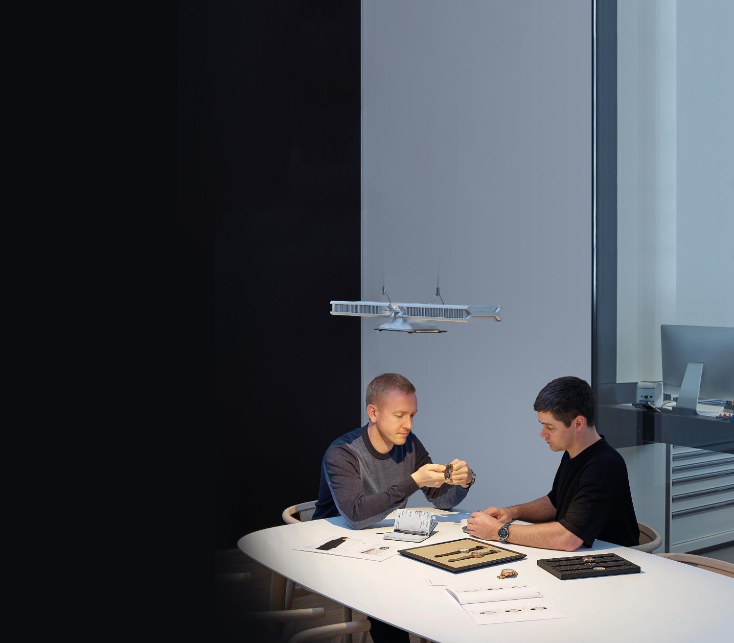 Two men working under the Dyson Cu-Beam light