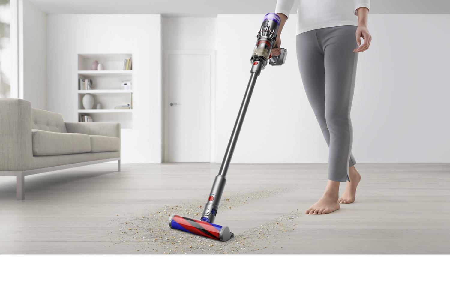 Vrouw gebruikt Dyson Omni-glide™ stofzuiger om harde houten vloer te reinigen.