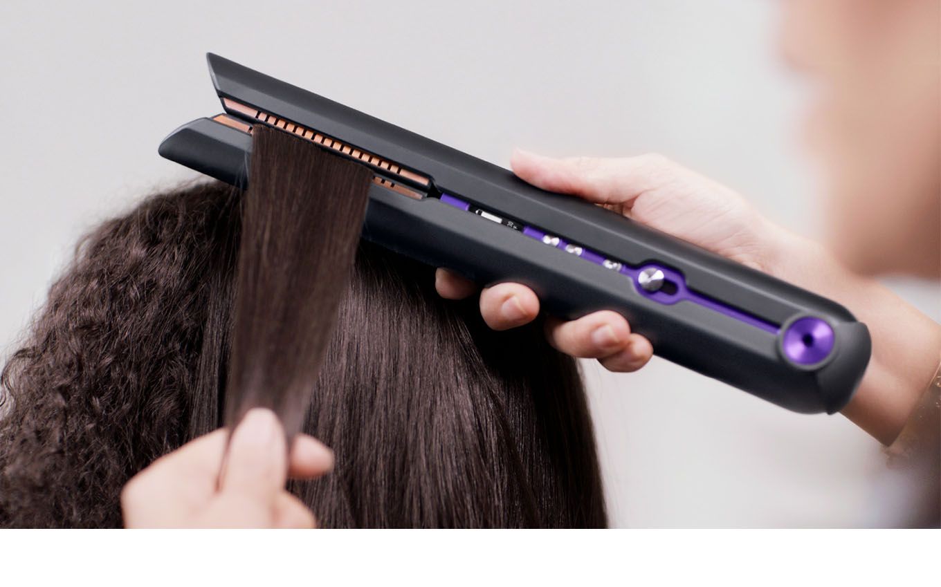 Professional hair stylist using the Dyson Supersonic hair dryer on a customer