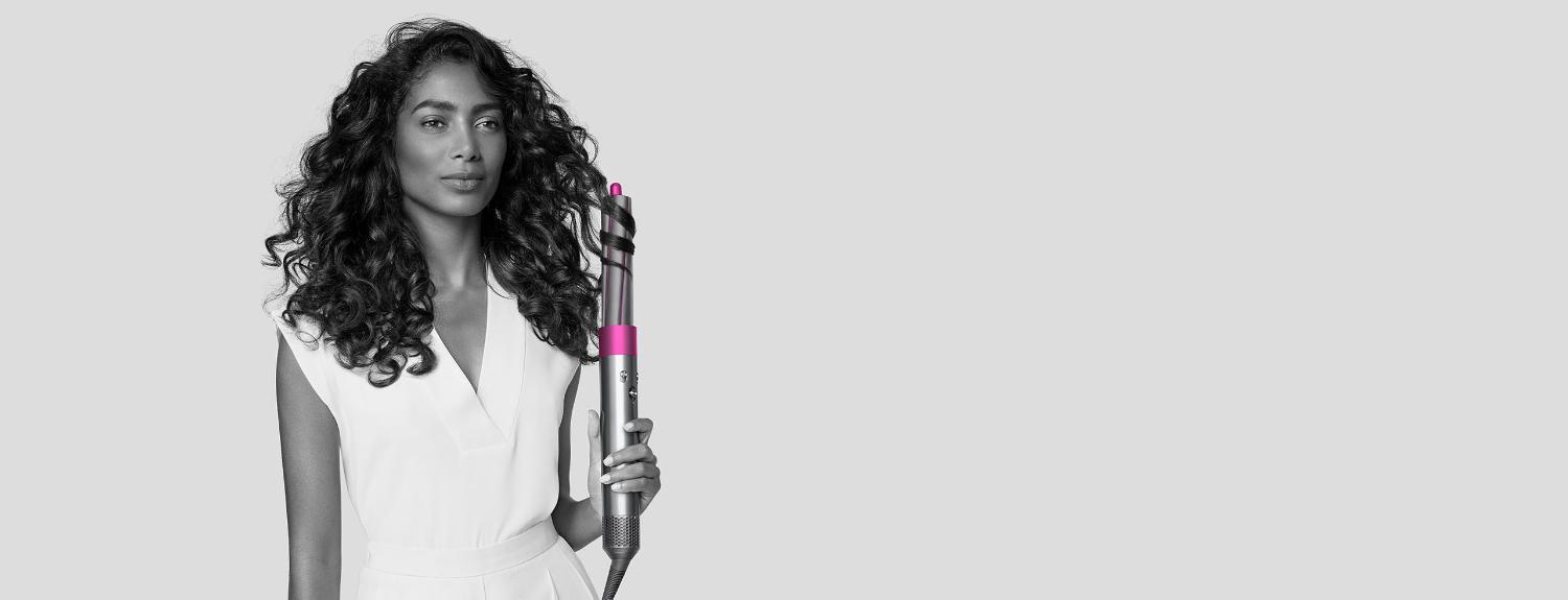 Woman styling hair with Dyson Airwrap styler.