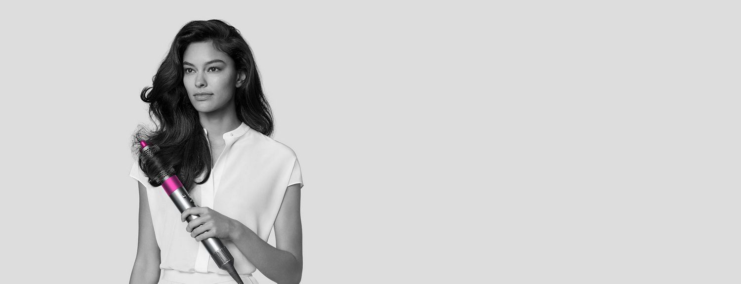 Personne aux cheveux bouclés utilisant la brosse ronde