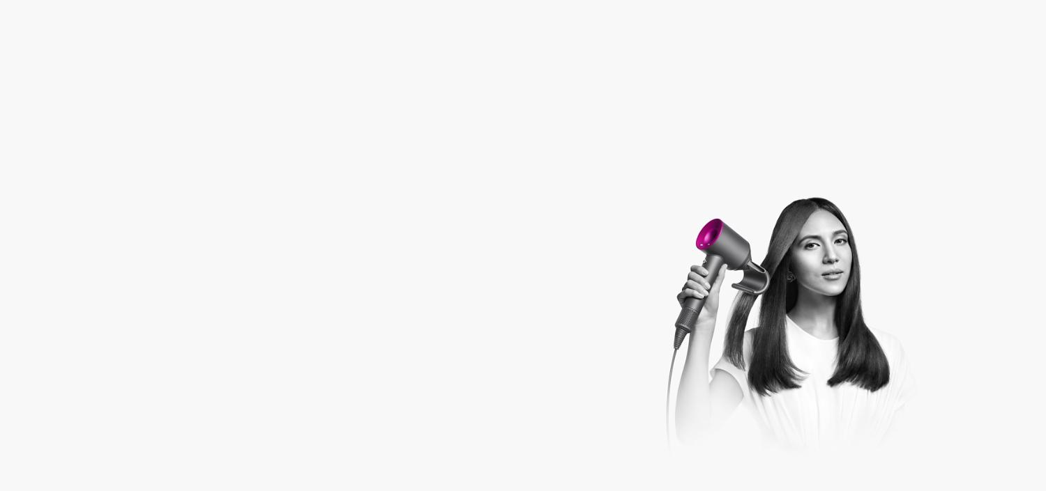 Femme se séchant les cheveux avec le sèche-cheveux Dyson Supersonic