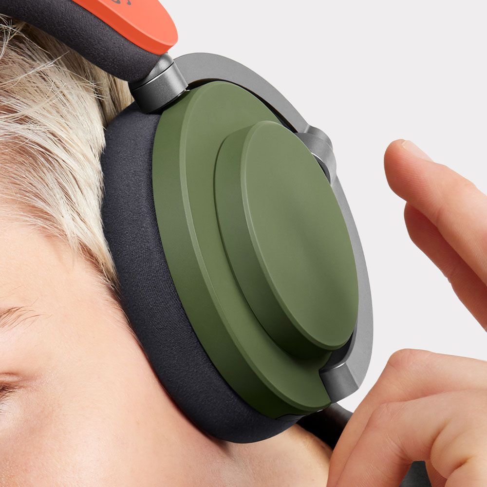 Gros plan sur un mannequin portant le casque audio Dyson OnTrac et qui s’apprête à appuyer sur le cache.