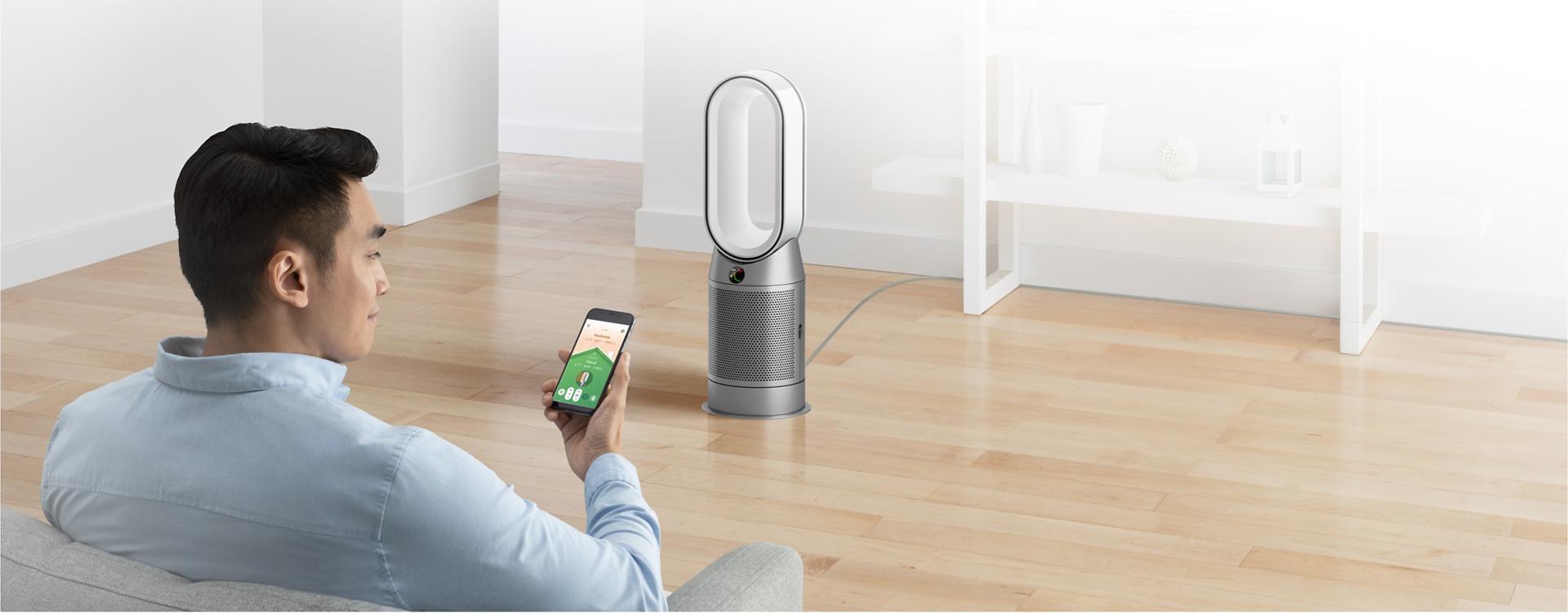 Man controlling Dyson Purifier with Dyson Link app
