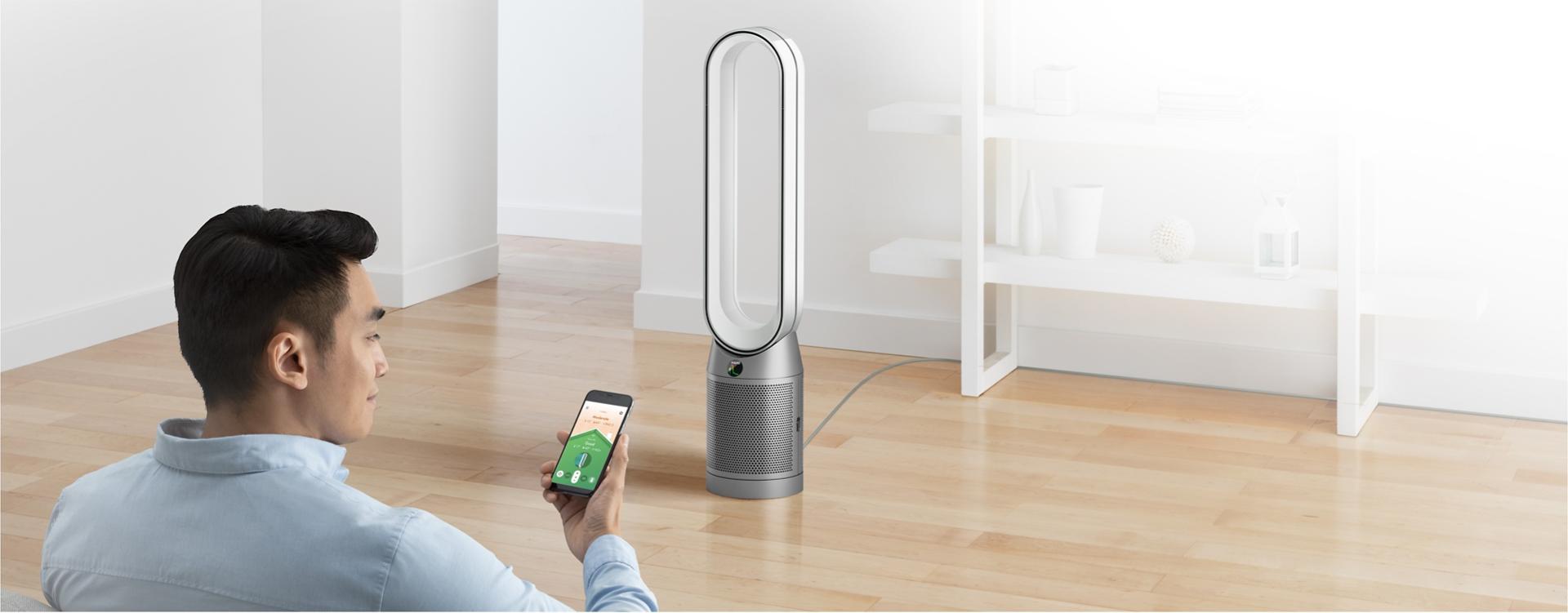 Man controlling Dyson Purifier with Dyson Link app