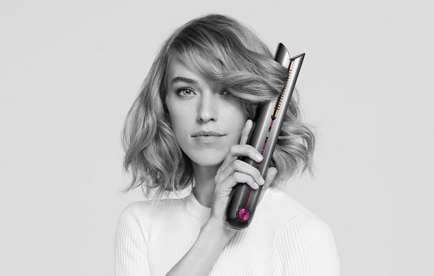 Model with short hair creating curls with a Dyson Corrale hair straightener