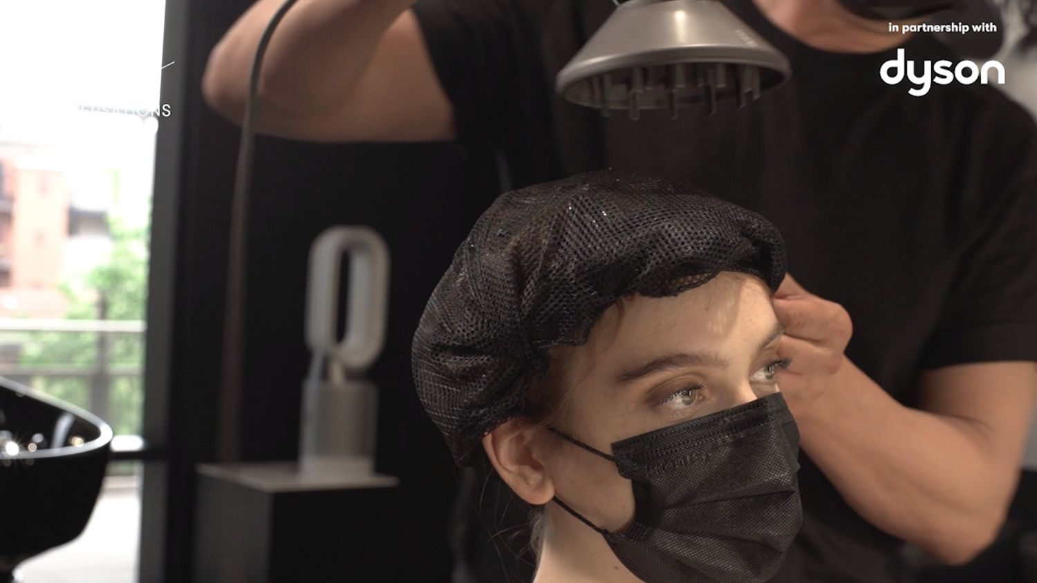 A model get their hair styled.