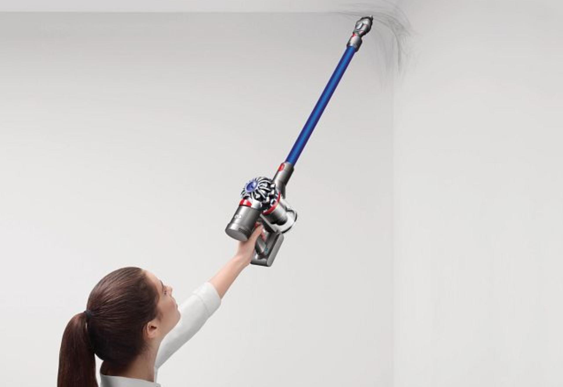 Women using Dyson vacuum to clean walls