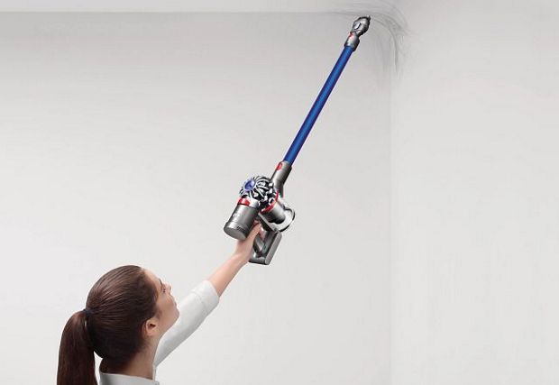 Women using Dyson vacuum to clean walls