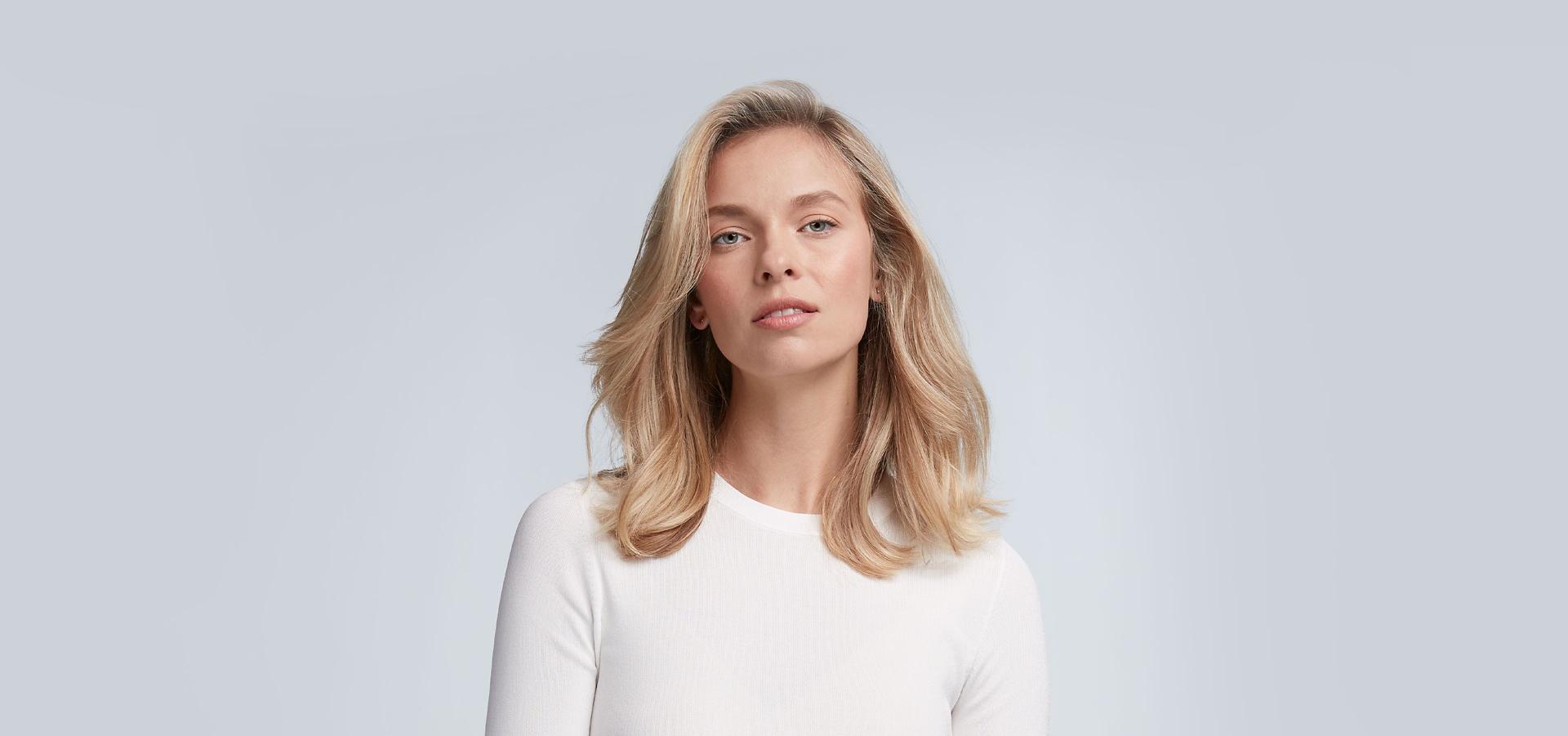 Modelka z farbowanymi włosami blond wystylizowanymi urządzeniem do stylizacji włosów Dyson