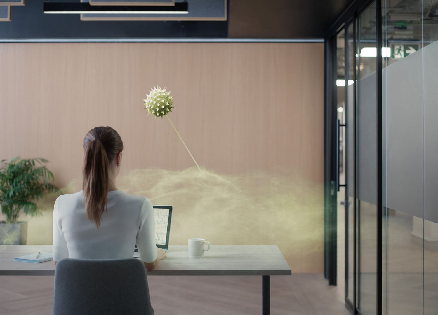 Pollen particles circulating in office and past woman sat at desk