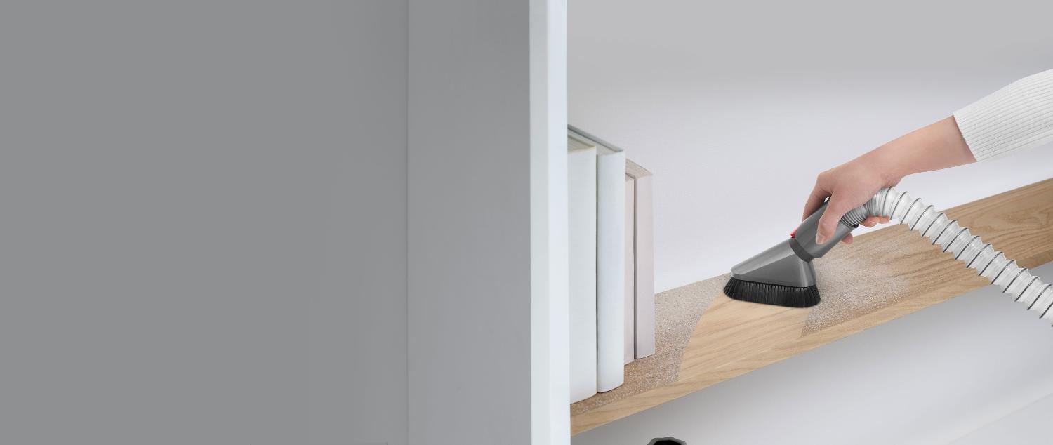 Vacuum attachment used to remove household dust on shelf