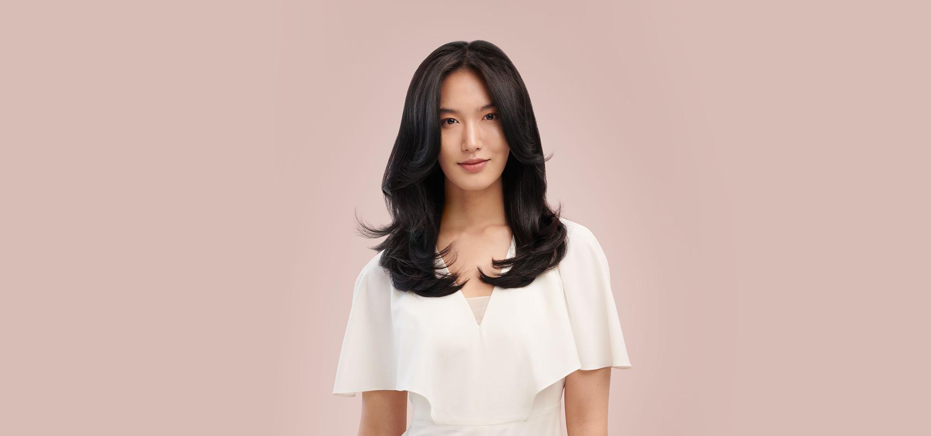 Kobieta z włosami wystylizowanymi przez urządzenie do stylizacji włosów Dyson