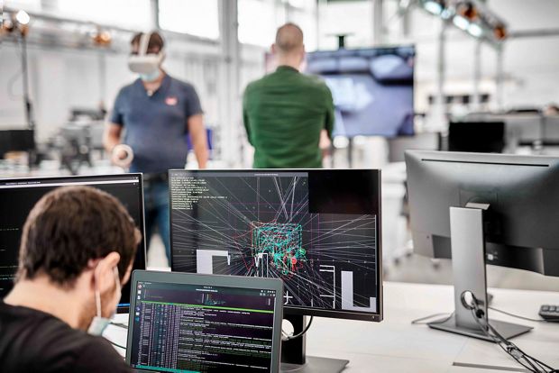 Dyson engineer working with CAD designs, with engineers using VR goggles.