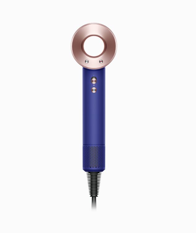 Woman with the Dyson Supersonic hair dryer with the diffuser attachment. 